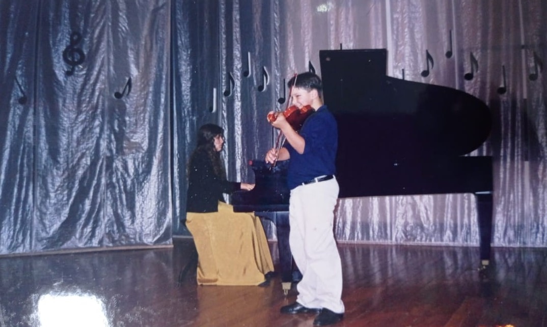 Guilherme Viana tocando violino quando era criança